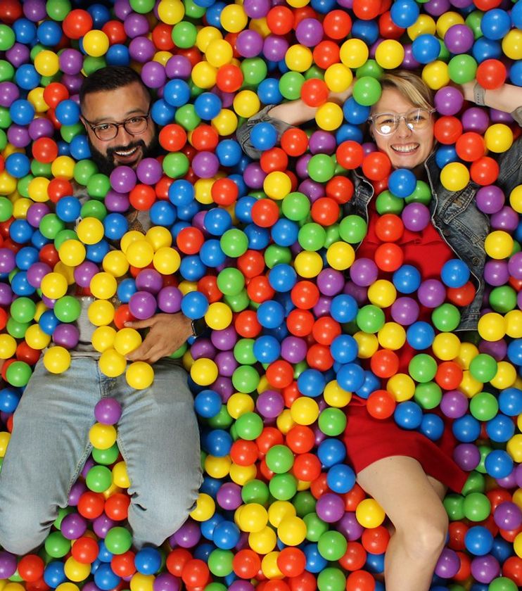 Guests smiling in a colorful ball pit photo booth
