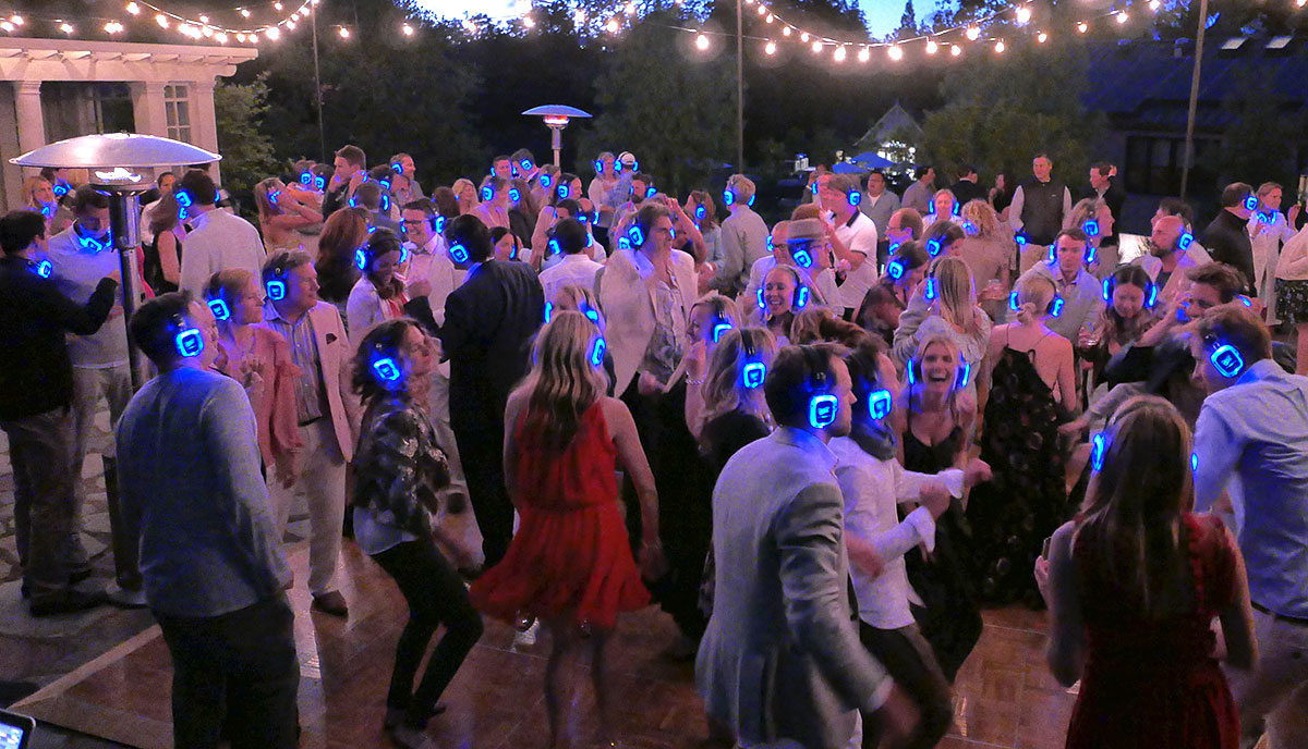 Outdoor event dance floor with guests under market lights