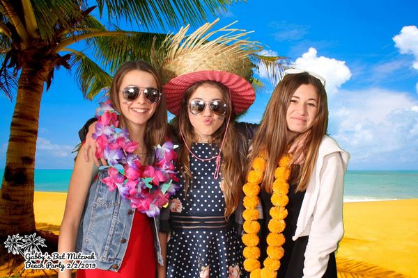Party guests posing with a green screen photo booth background