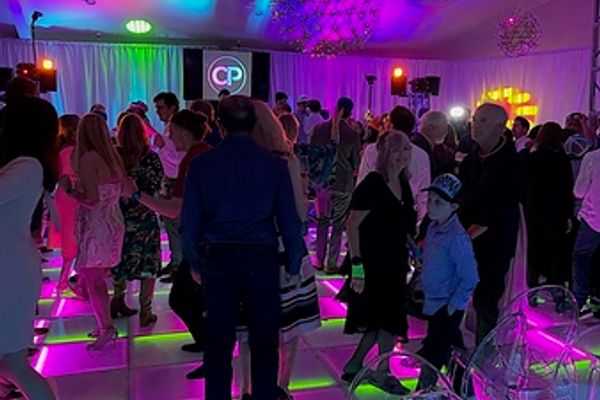 Guests celebrating beside a light-up LED dance floor