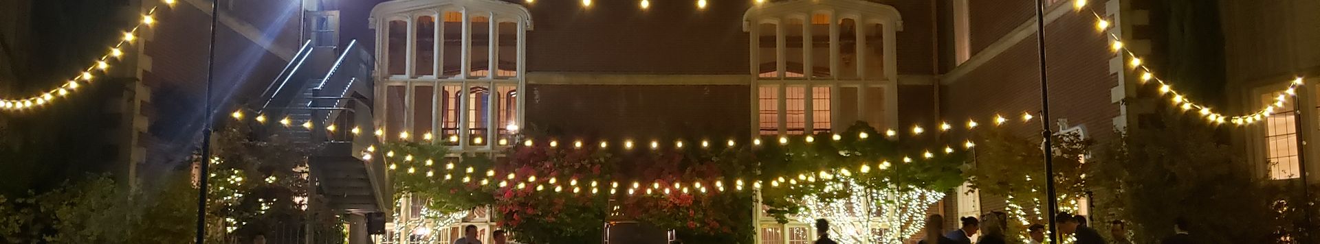 Outdoor event space with warm lighting and guests
