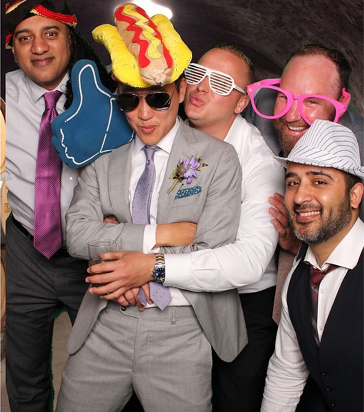 Guests posing at a classic photo booth with props