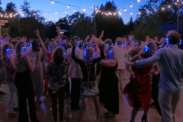 Silent disco crowd dancing with glowing headphones