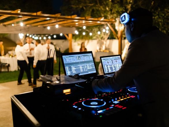 Wedding DJ setup with guests dancing at a reception